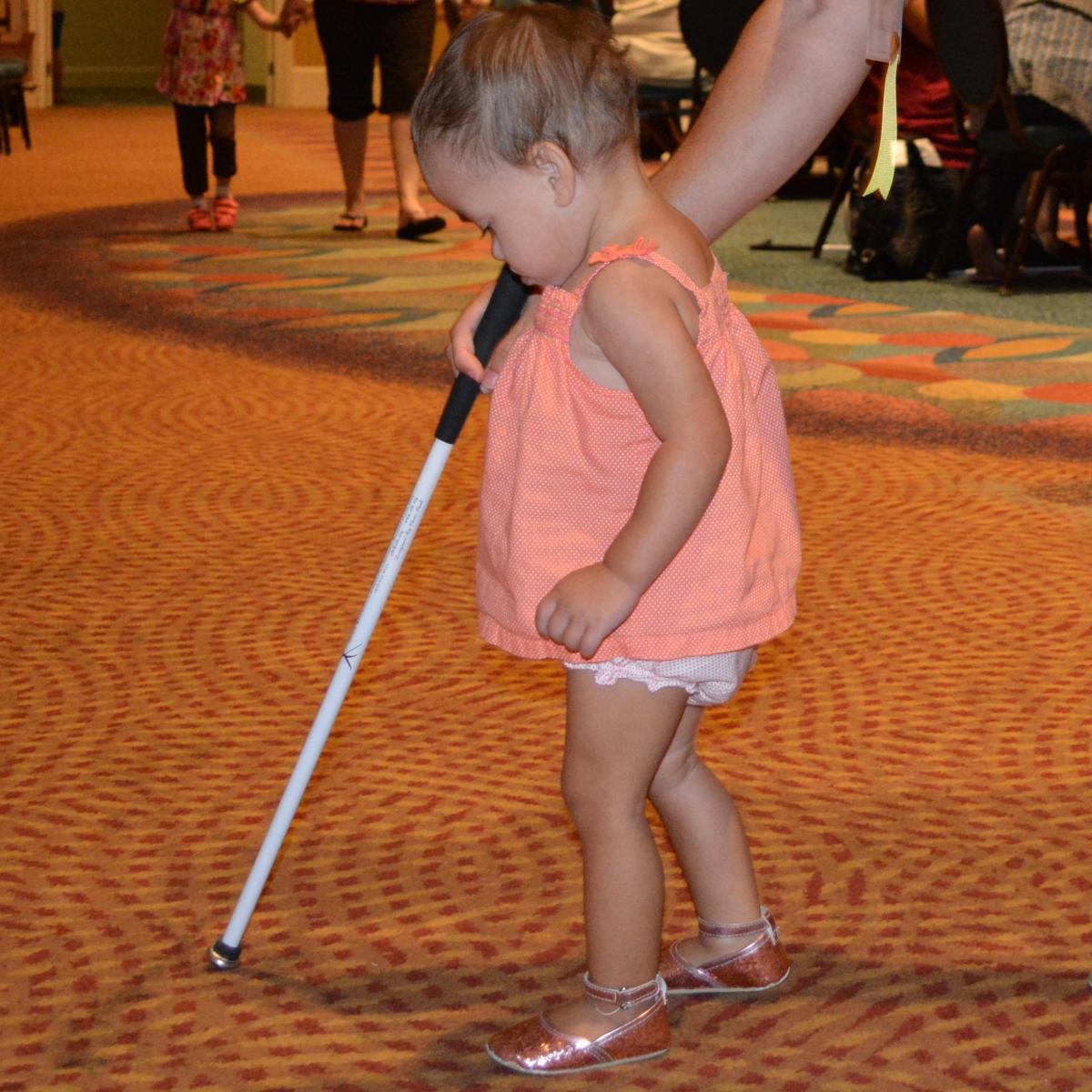 toddler using long white cane.